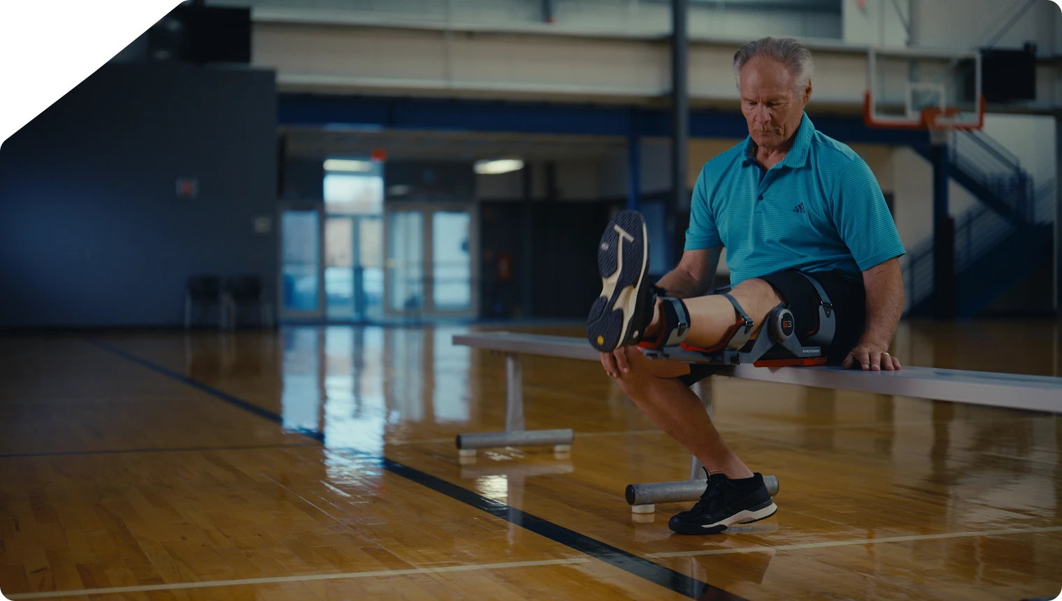 Man stretching his leg on a basketball court